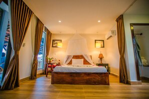 Une chambre à coucher avec un lit en bois, un baldaquin, une table de chevet avec une lampe et des rideaux.