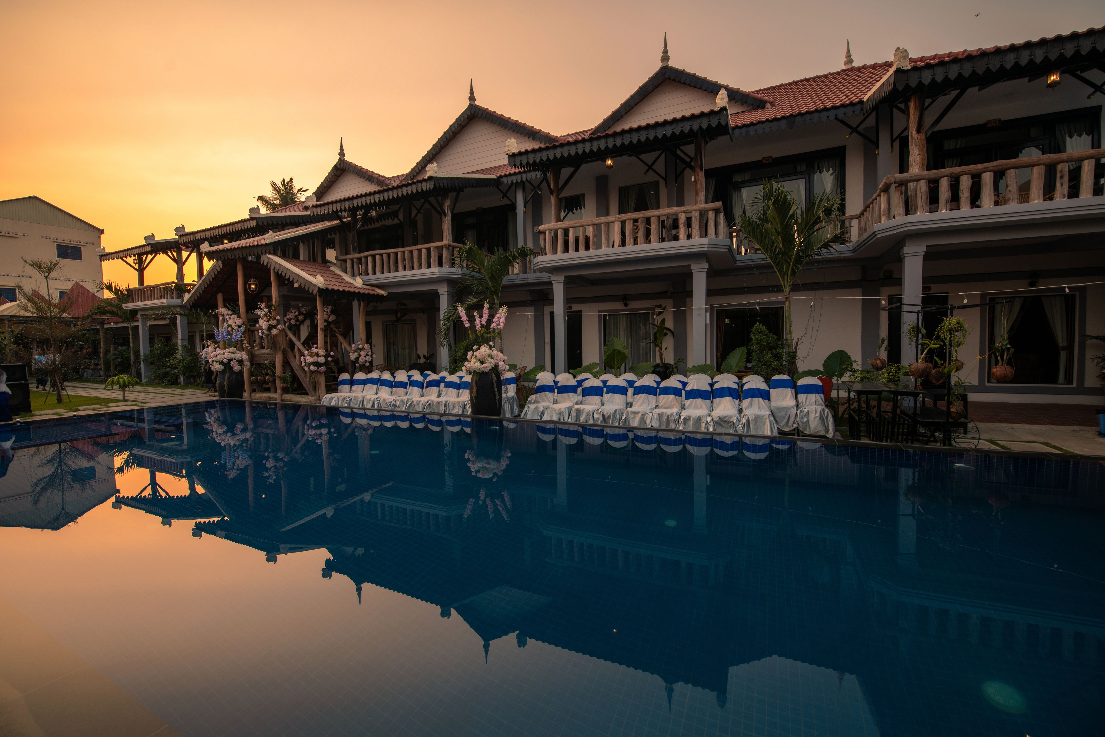A hotel with a swimming pool, traditional architecture, and balconies.