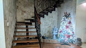 A staircase with wooden steps and a metal railing, leading to a tiled floor area. - Hotel Casa Aluge (Santo Domingo)