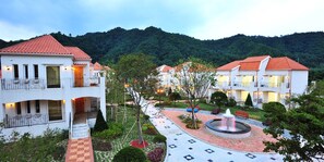 Ein Hotel mit mehreren weißen Gebäuden, roten Ziegeldächern und einem zentralen Innenhof mit einer Springbrunnen.