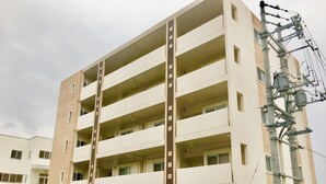 Un edificio residencial de varios pisos con estacionamiento.