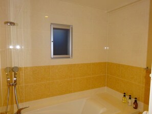 A bathroom with a bathtub, a shower, and a window. - Coldio Clover Kuwae (Chatan)