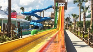 Een waterpark met meerdere glijbanen in blauw, groen, geel en rood.