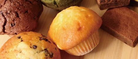 A variety of baked goods including muffins and cookies on a wooden surface.