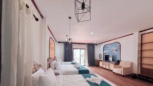 Une chambre d’hôtel avec deux lits, une télévision, un bureau et une grande fenêtre.