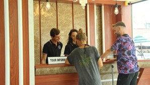 Un comptoir d’accueil avec une pancarte indiquant « RENSEIGNEMENTS TOURISTIQUES » et un lustre au-dessus.