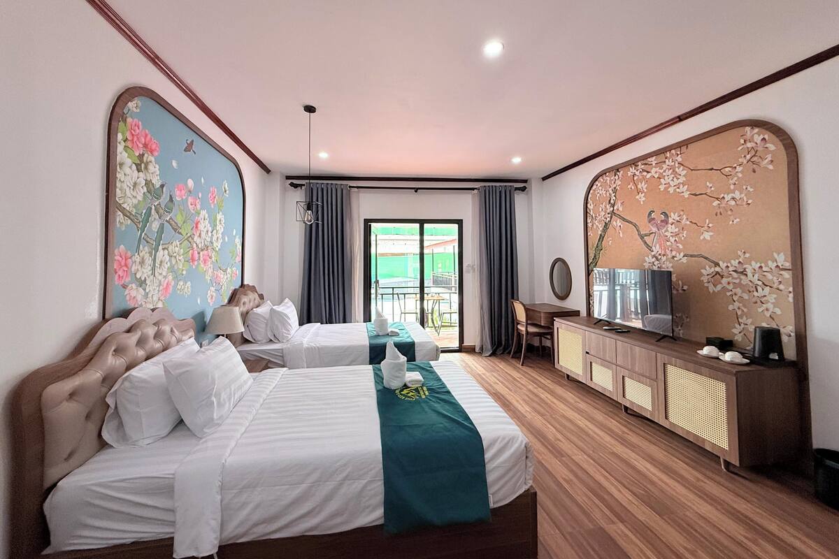 Une chambre d’hôtel avec un lit, un bureau, une télévision et une grande fenêtre.