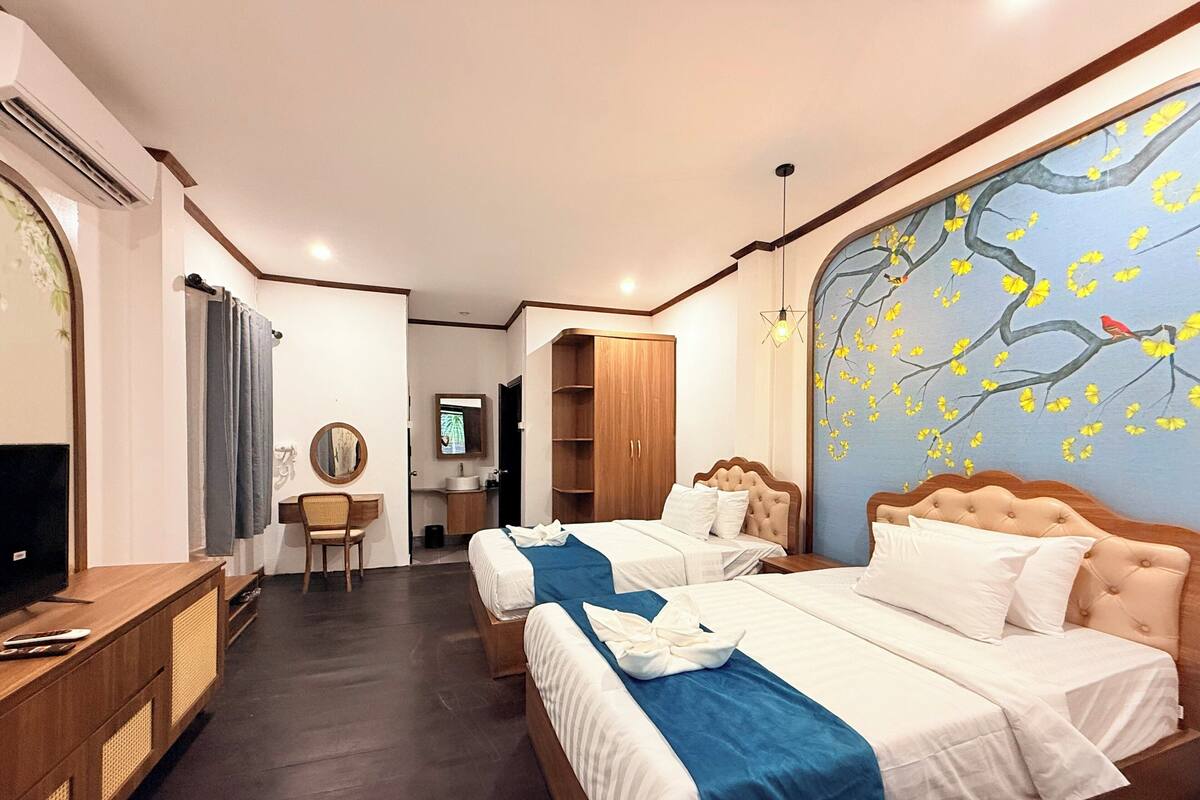Une chambre d’hôtel avec deux lits, un bureau, une télévision et une salle de bain.