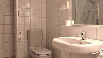 A bathroom with a toilet, sink, and shower.