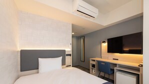A hotel room with a bed, a desk with a chair, a television, and an air conditioning unit. - Keikyu Ex Inn Yokohama Station East (Yokohama)