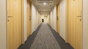 A long, narrow hallway with carpeted floors and wooden doors numbered 1009 and 1006. - Keikyu Ex Inn Yokohama Station East (Yokohama)