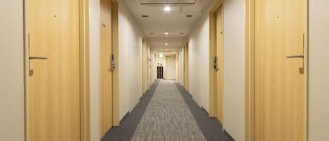 A long, narrow hallway with carpeted floors and wooden doors numbered 1009 and 1006.
