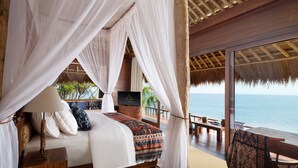 Un dormitorio con cama, televisor y vista al mar.