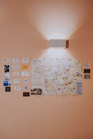 A wall with a map of Rome, informational cards, and a light fixture.