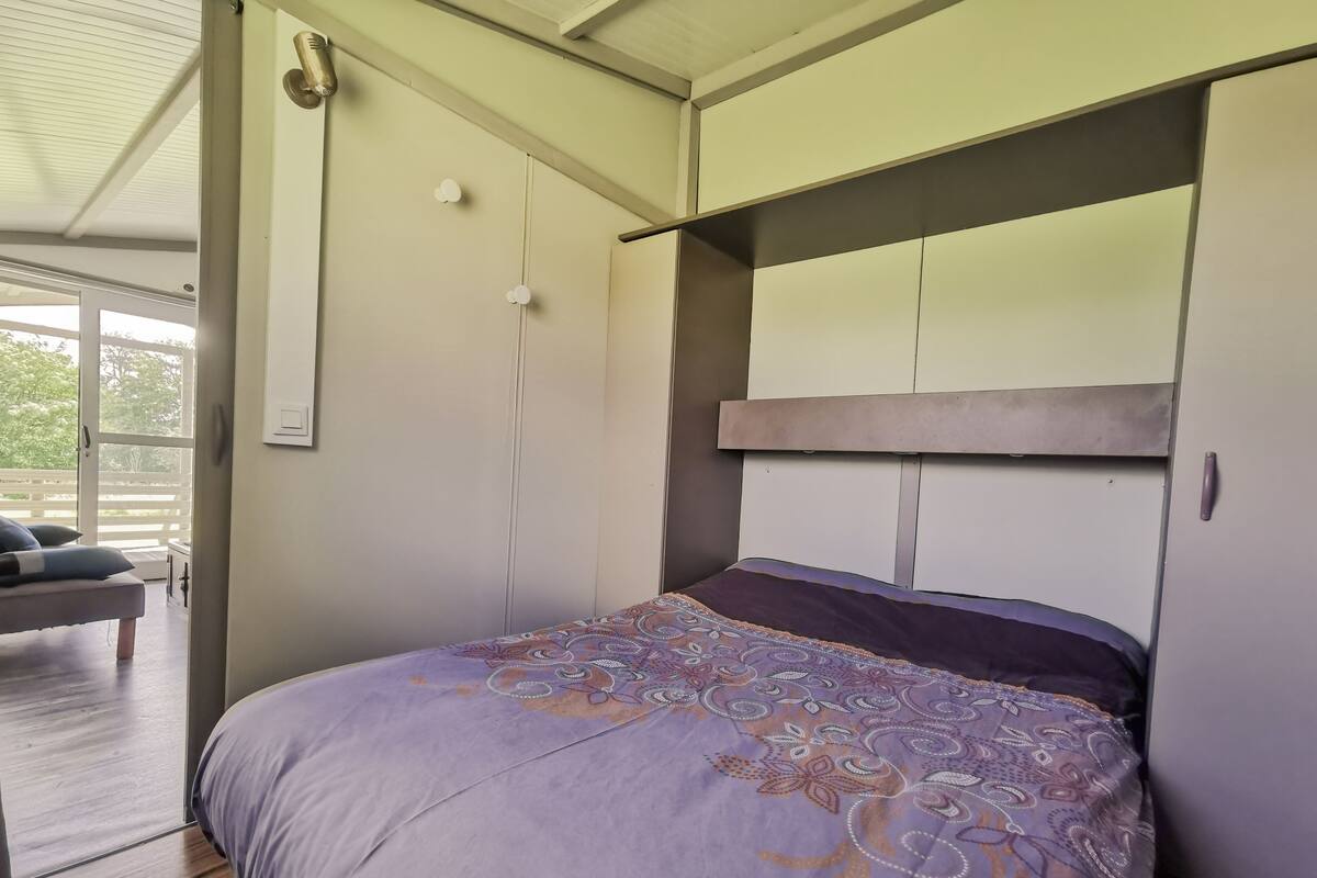 A bedroom with a bed, a wardrobe, and a window.