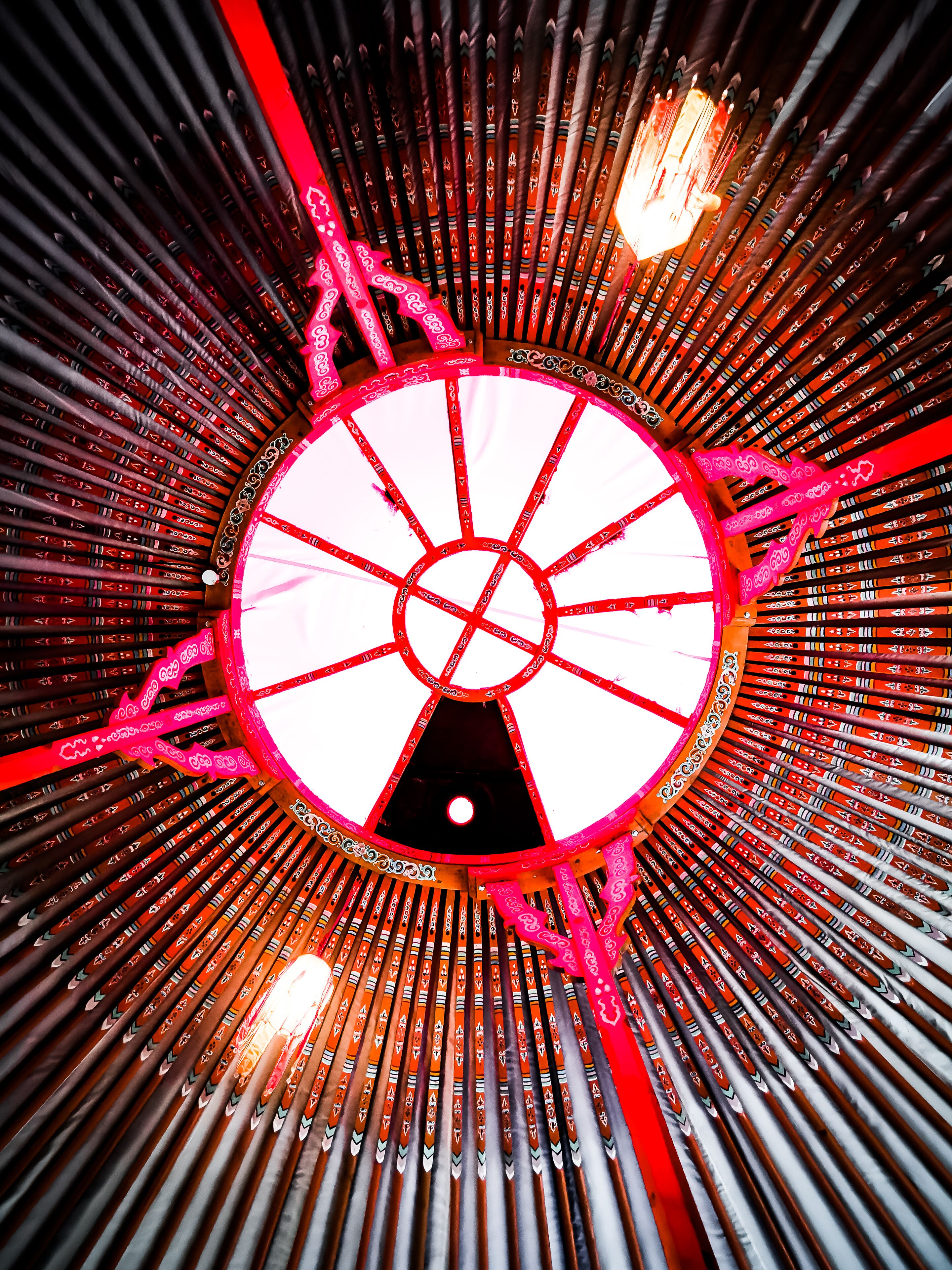 A circular architectural structure with a central light source and radiating beams.