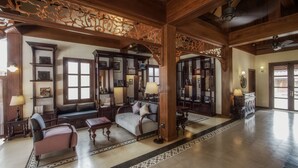 A spacious lobby with a high ceiling, wooden beams, and a large seating area with sofas and armchairs. - Le Bel Air Resort Luang Prabang (Luang Prabang)