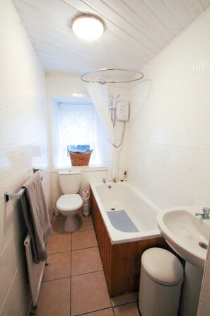 Une salle de bain comprenant des toilettes, une baignoire et un lavabo.