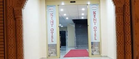 Der Eingang zum Midyat Kent Hotel mit rotem Teppich und doppelten Türen.