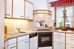 A kitchen with white cabinets, a built-in oven, and a sink.