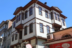A multi-story building with a traditional architectural style, featuring a corner entrance and multiple windows.