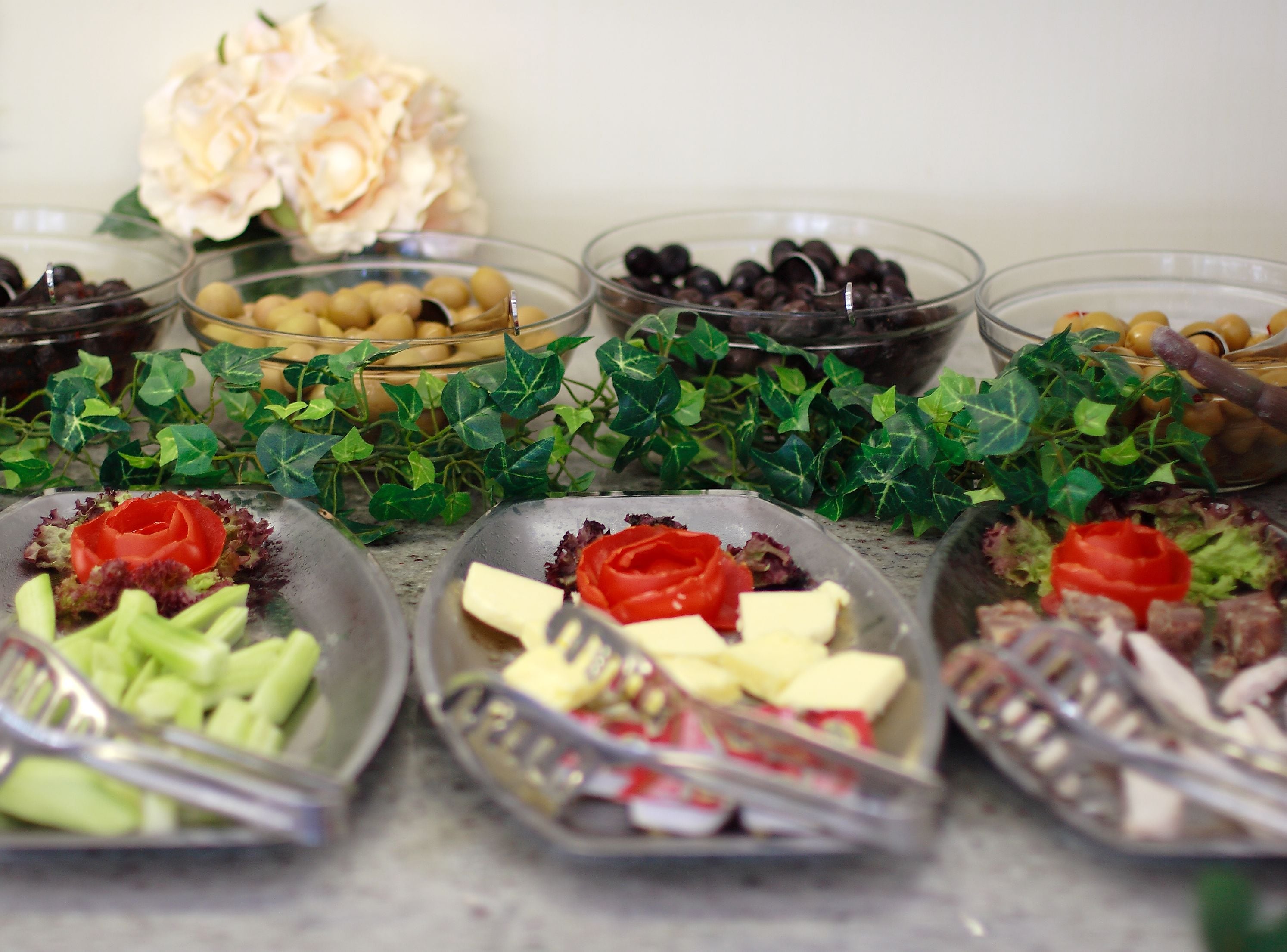 Un buffet proposant une variété de plats, notamment des olives, du fromage et des légumes.