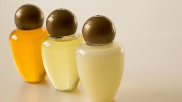 Tres ampolles de perfum amb líquids de colors diferents i taps marrons.