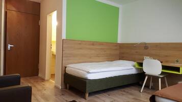 A room with a bed, a desk, and a chair.