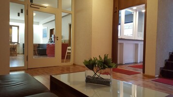 Una sala de estar moderna con una mesa de centro de vidrio, un sofá y una planta.