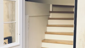 Una escalera con escalones de madera y paredes blancas.