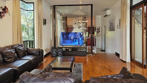 Una sala de estar moderna con un sofá de cuero, una mesa de centro de vidrio y un televisor de pantalla plana.