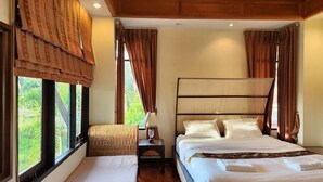 Un dormitorio con una cama grande, techo de madera y vistas a zonas verdes a través de la ventana.
