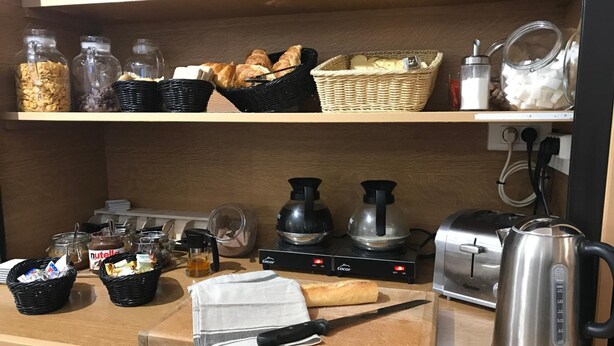 A kitchen counter with various breakfast items, including cereal, bread, and condiments. There are also coffee-making equipment and a toaster. - Tourhotel (Béthune)