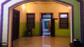 A hallway with an archway, a bench, and a door leading to another room. - Yarl Crown Inn (Kandy)