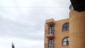 Een meerlaags gebouw met balkons en grote ramen.