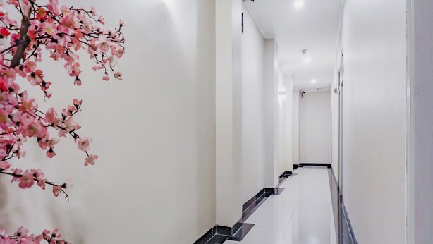 A long, narrow hallway with white walls and a tiled floor. - OYO 117 Blueberry Homestay (Jakarta)