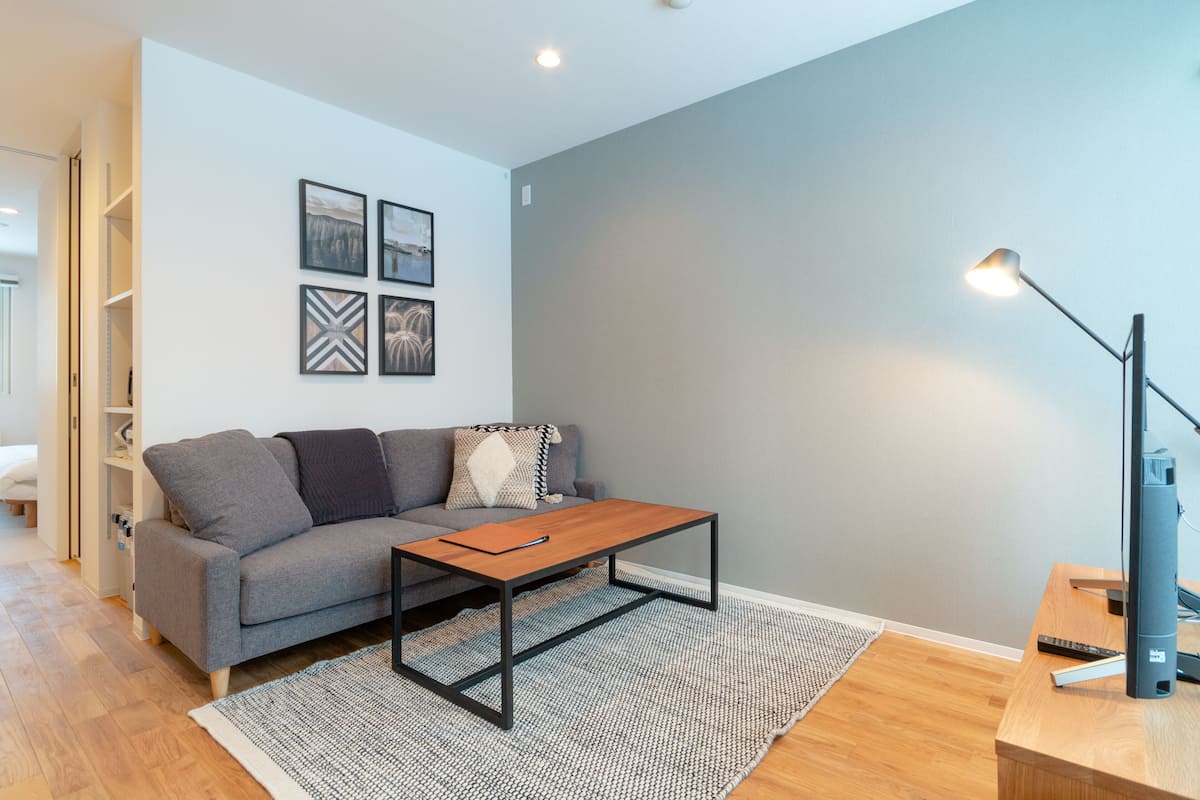 A modern living room with a grey sofa, a wooden coffee table, and a floor lamp.