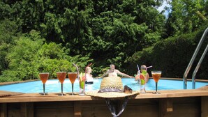 A wooden deck with a pool, surrounded by lush greenery. - La Croix du Reh (Châteauneuf-la-Forêt)