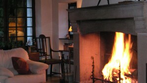 A cozy living room with a fireplace, a sofa, and a coffee table. - La Croix du Reh (Châteauneuf-la-Forêt)