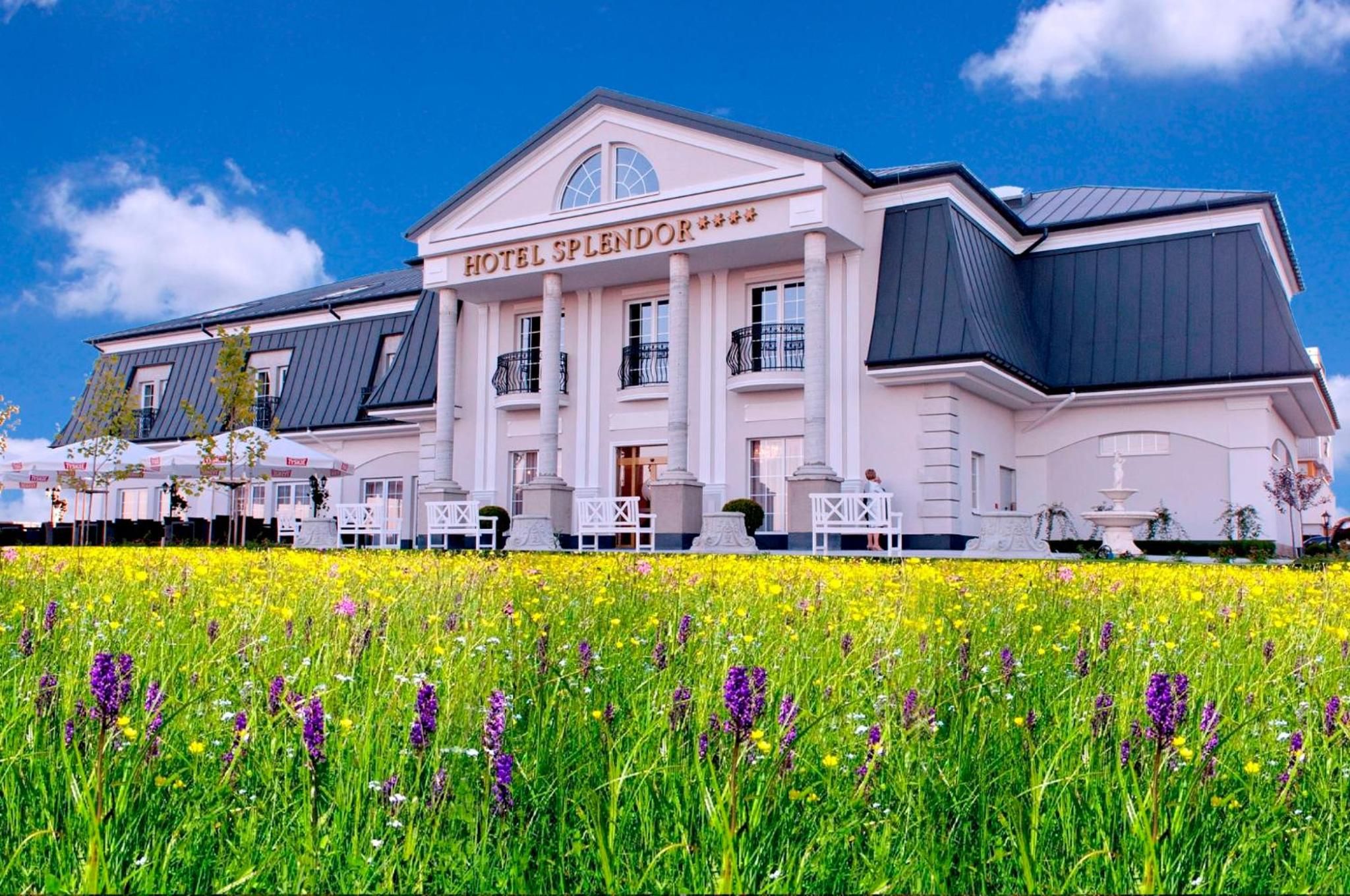 En stor, hvid hotelbygning med et tydeligt skilt, der siger 'HOTEL SPLENDOR'.