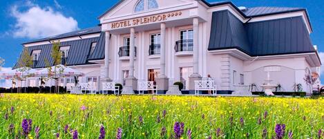 Un hotel grande y blanco con un letrero destacado que dice 'HOTEL SPLENDOR'.