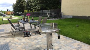 A patio with a grill, outdoor seating, and a playground in the background. - Bett & Bike Eden (Senftenberg)