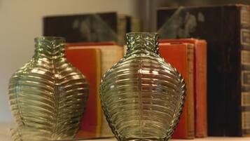 Two green glass vases with ribbed patterns on a shelf.