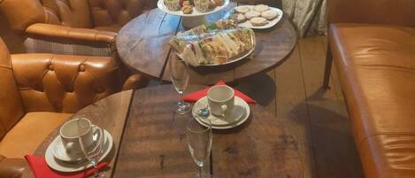 Un comedor con una mesa de madera dispuesta para una comida, rodeado de sillas de cuero.