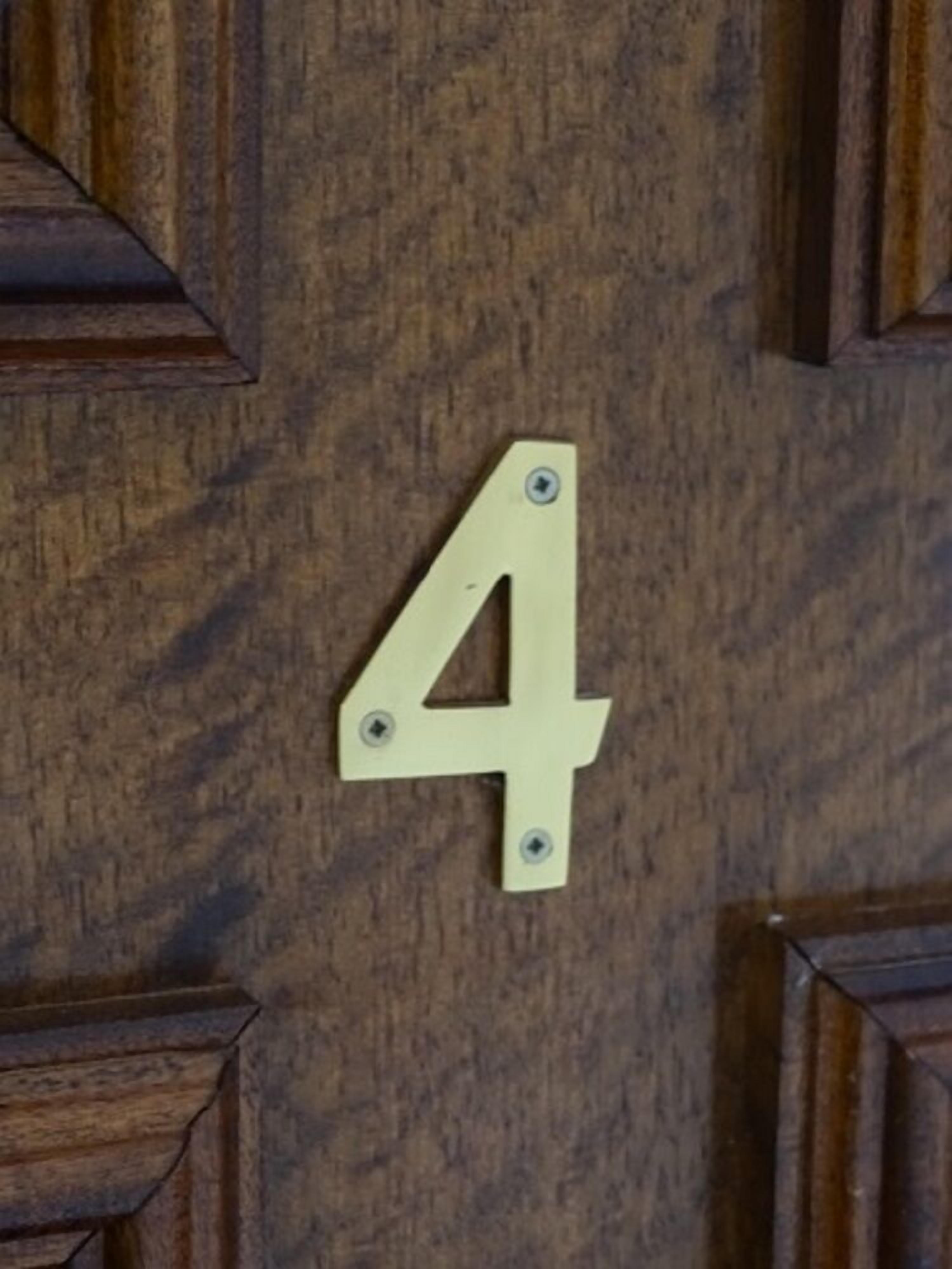 A wooden door with a brass number plate indicating room number 4.