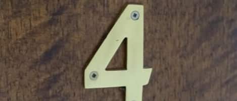 A wooden door with a brass number plate indicating room number 4.