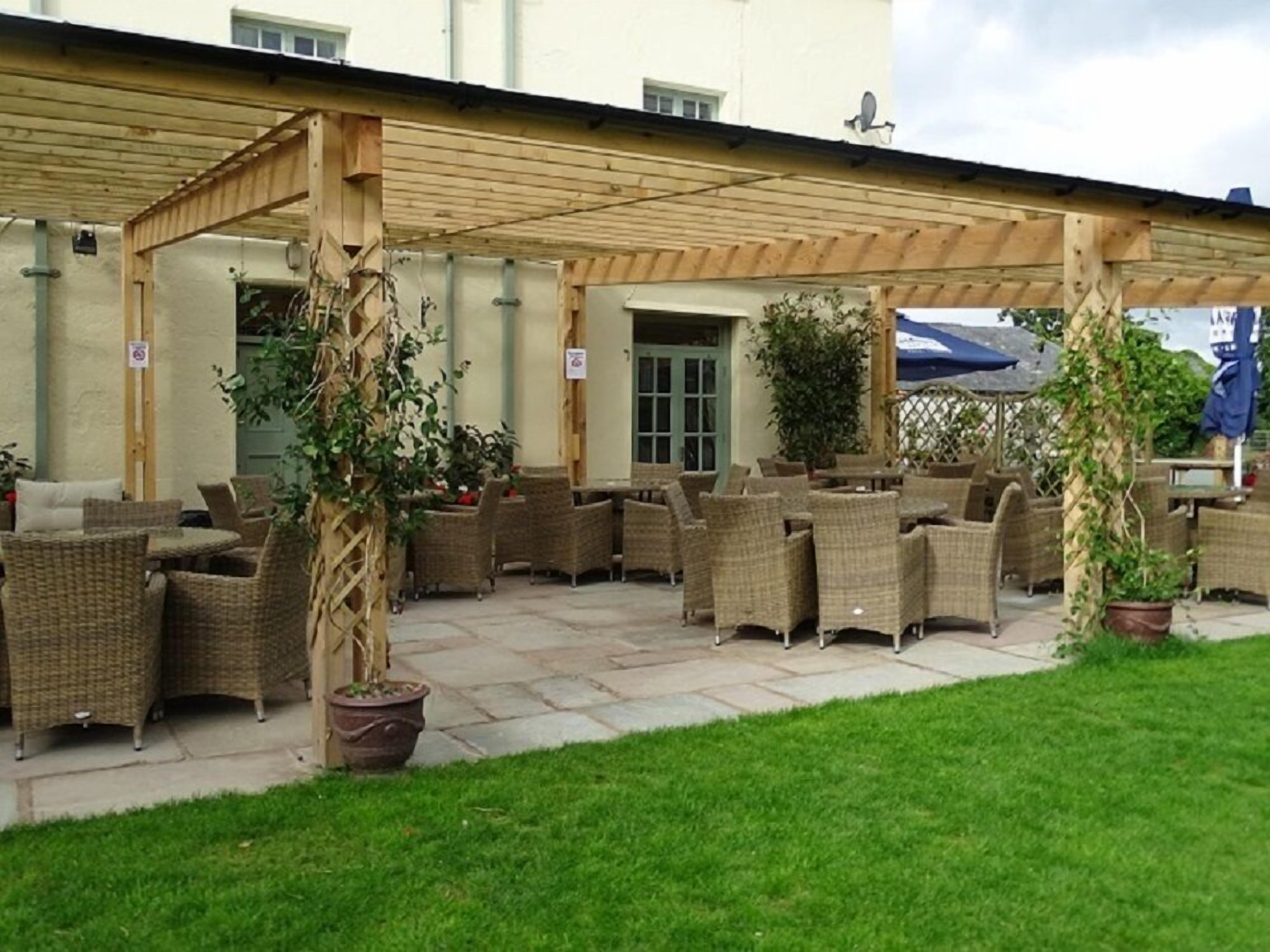 An outdoor patio area with wicker furniture and potted plants.