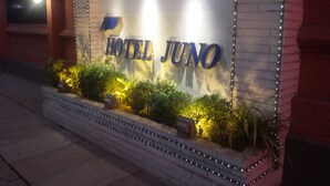 A hotel sign with the name "HOTEL JUNO" illuminated.