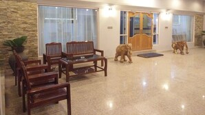 A spacious lobby with a stone wall, large windows, and a wooden door.