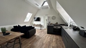 Un appartement moderne de style « loft » comprenant une cuisine, un coin repas et un espace de vie.